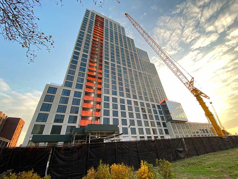 the tall side of 227 west street rising over a new park on the east river