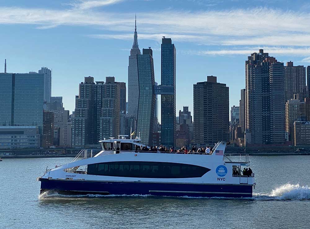 NYC Ferry in the East River with the Empire State Building in the Background. Service was suspended to Greenpoint after a problem was discovered with the pilings