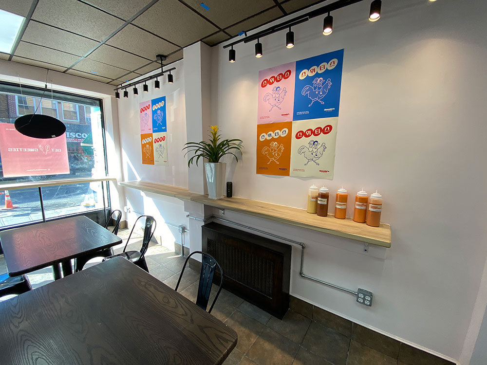 Colorful posters decorate the interior of Sweetie's K Chicken in Greenpoint