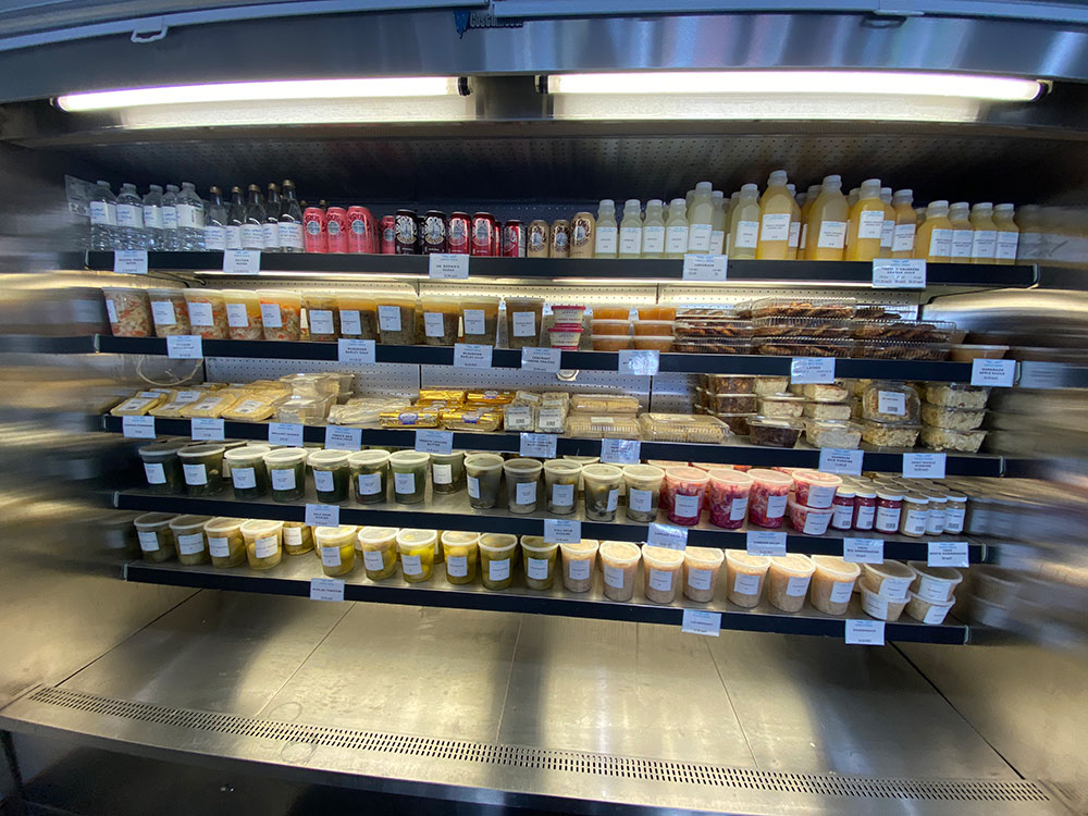 Simply Nova has a refrigerator section with branded bottled water, drinks, cold soups, cheese blintzes, salads, cold sweets, and lots of pickles