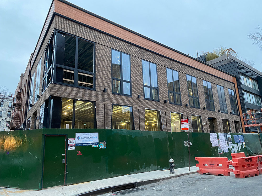 Bedford Avenue two-story building with brown brick and black window trim